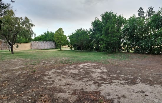 Open area with pole fence in background.